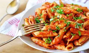 Penne w pikantnym sosie pomidorowym, posypane świeżą bazylią. Idealne spaghetti arrabiata na obiad.