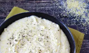 Pyszna, kremowa polenta z mąki kukurydzianej, doprawiona świeżo mielonym pieprzem, gotowa do podania.