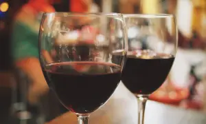 Dwa kieliszki czerwonego wina, być może słodkiego muscat alkohol, na rozmazanym tle.