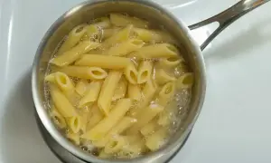 Penne rigate gotują się w garnku na kuchence.