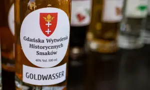 Butelka z etykietą "GOLDWASSER" i herbem Gdańska. To historyczna wódka gdańska, która kusi smakiem.