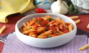 Penne all'arrabiata, czyli pikantny sos pomidorowy z czosnkiem i chili, idealny do tego przepisu.