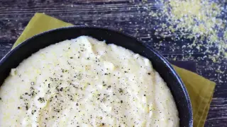 Pyszna, kremowa polenta z mąki kukurydzianej, doprawiona świeżo mielonym pieprzem, gotowa do podania.