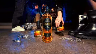 Impreza w toku, butelka Grant's Triple Wood 8 Years i drinki z pomarańczą.