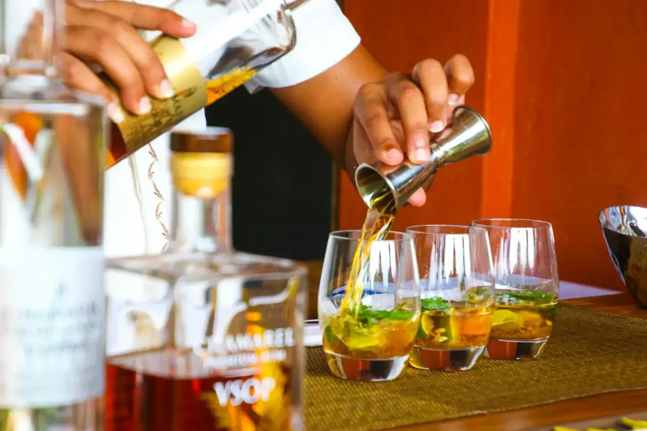 Barman nalewa rum VSOP do szklanek z lodem i miętą. Idealny drink na upalne popołudnie.