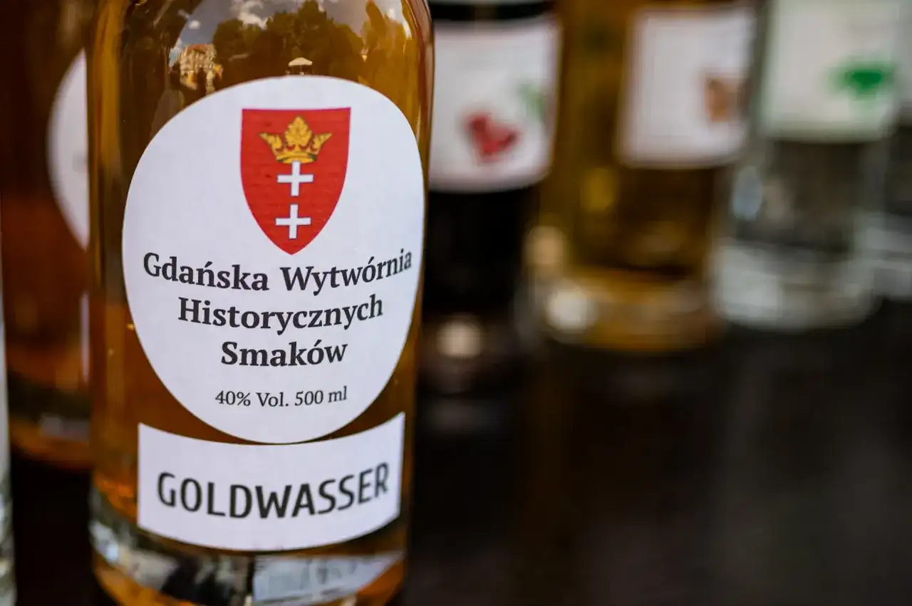 Butelka z etykietą "GOLDWASSER" i herbem Gdańska. To historyczna wódka gdańska, która kusi smakiem.
