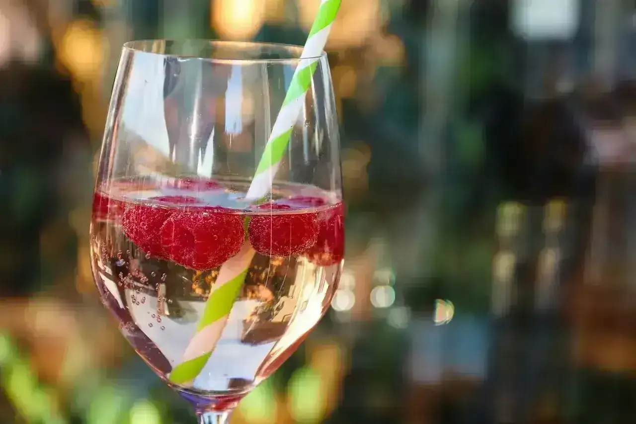 Orzeźwiający drink z malinami i słomką, idealny na letnie wieczory. Smakuje jak Bacardi Raspberry.
