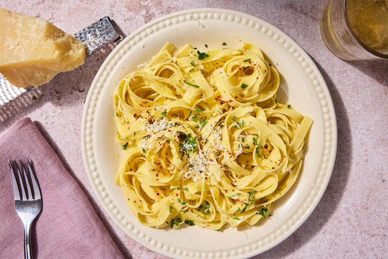 Talerz tagliatelle z parmezanem i natką pietruszki. Czy pszenica durum ma gluten? Tak, zawiera go, co nadaje makaronowi jego charakterystyczną strukturę.