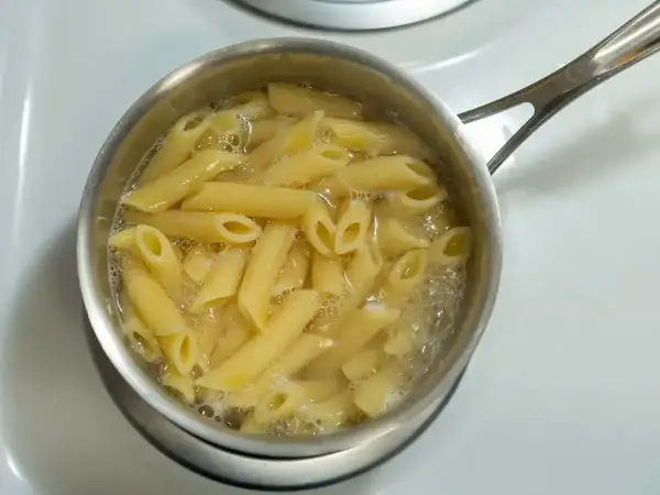 Penne rigate gotują się w garnku na kuchence.