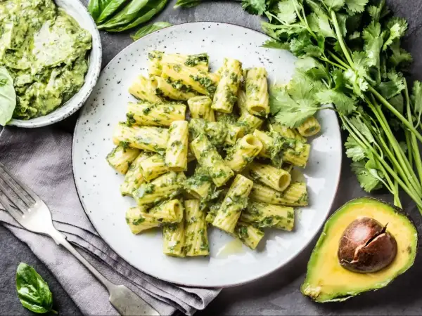 Pyszny makaron rigatoni z zielonym pesto, podany z awokado i świeżą kolendrą. Idealna ilość pesto do makaronu.