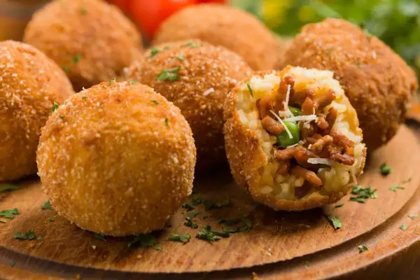 Chrupiące arancini, pyszne włoskie dania mięsne, z bogatym nadzieniem mięsnym i groszkiem, posypane parmezanem.