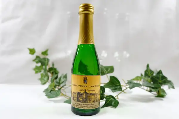 Butelka piccolo z zielonego szkła z etykietą "Riesling Sekt trocken" od Gloria Thurn und Taxis. Czy piccolo ma alkohol? Tak, to wino musujące.
