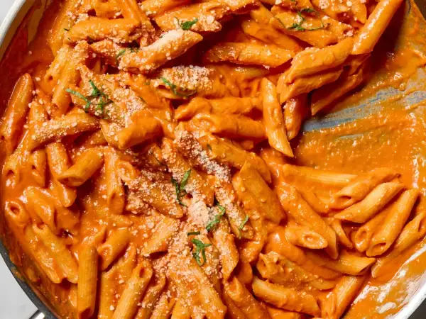 Penne w kremowym sosie z pomidorów pelati, posypane parmezanem i bazylią. Pyszne danie, które zachwyci każdego.