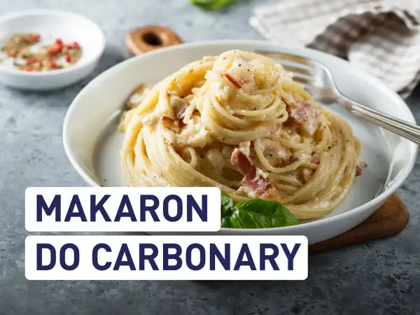 Pyszny makaron do carbonary, idealnie kremowy, z kawałkami boczku i posypany pieprzem.