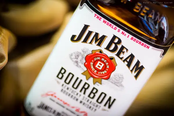 Butelka Jim Beam White Label, z charakterystycznym logo i napisem "Bourbon". Idealna na wieczór z przyjaciółmi.